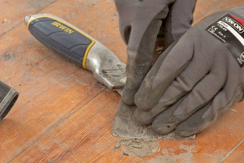 Klargjøring gulvsliping: Limrester, sparkelmasse og lignende skrapes vekk Klargjøring gulvsliping: Limrester, sparkelmasse og lignende skrapes vekk